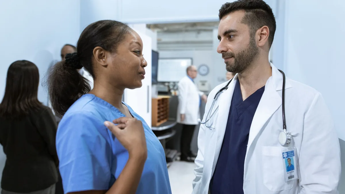 Medical professionals discussing patient care in a hospital hallway.