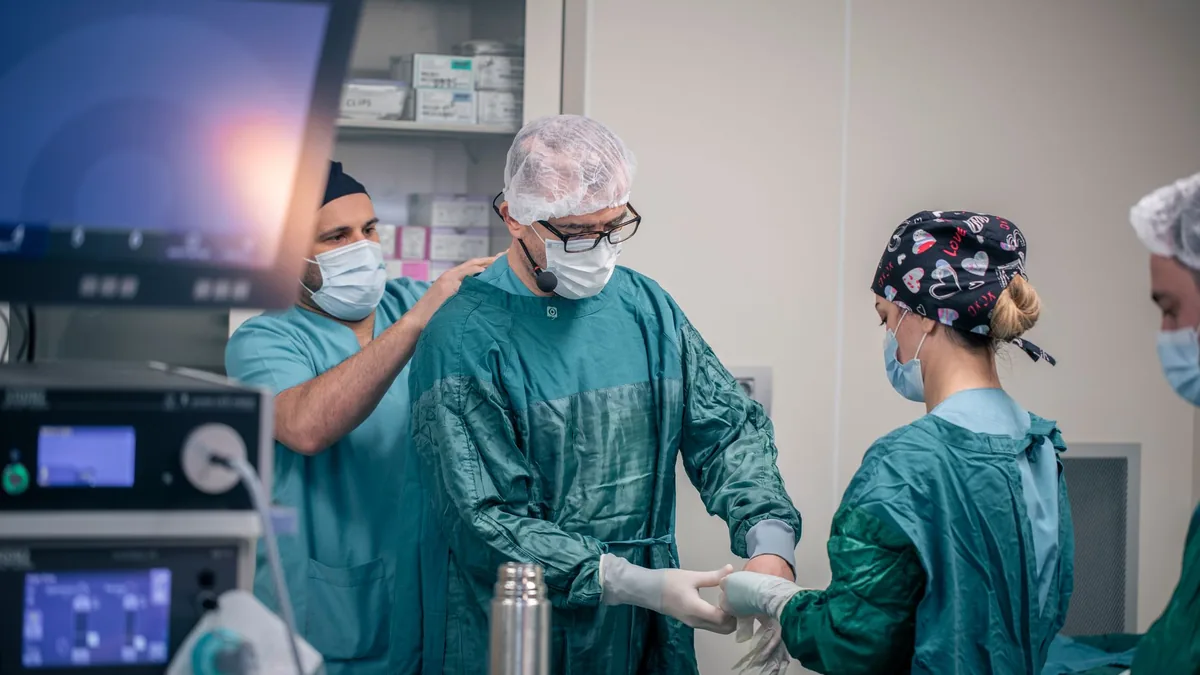 Medical professionals prepare for surgery in a hospital operating room.